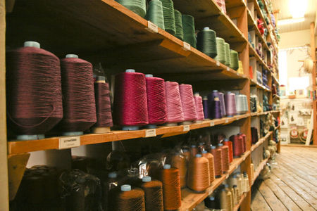 Halcyon Yarn retail store shelving with colorful cones of yarn
